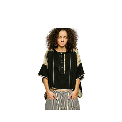 Woman wearing a black and gold top with striped pants on a white background